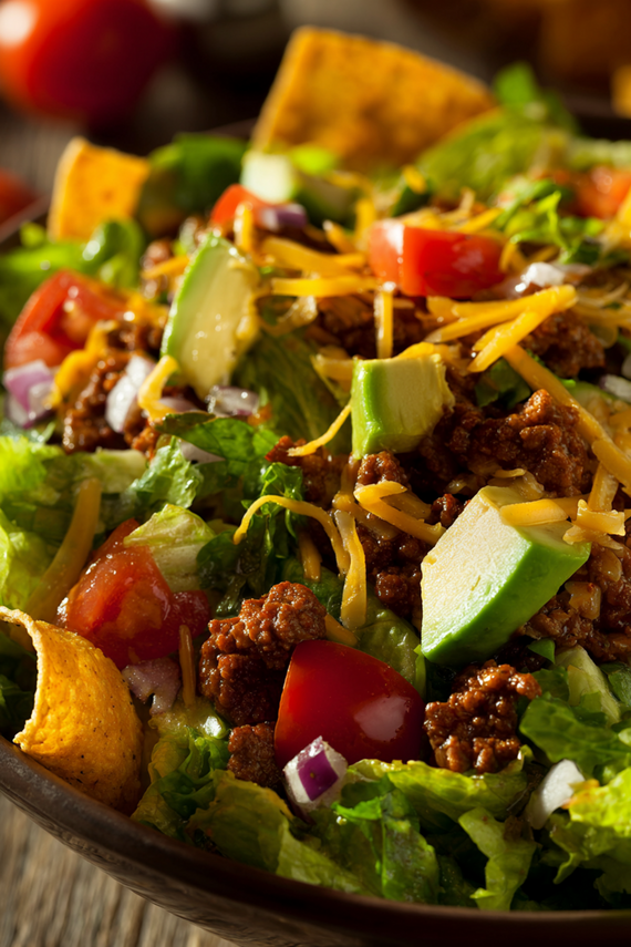Traditional taco salad recipe with all toppings arranged in a large serving bowl