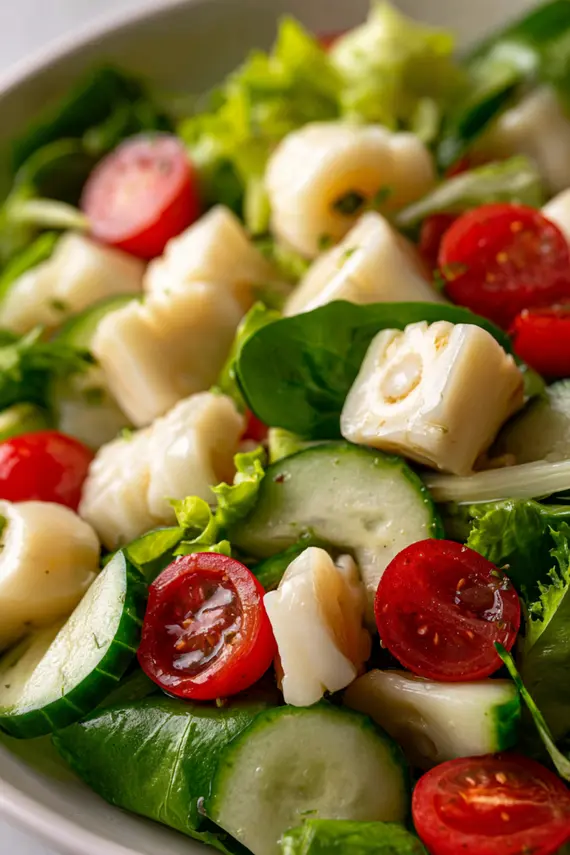 Closeup of hearts of palm salad in a white bowl garnished with herbs