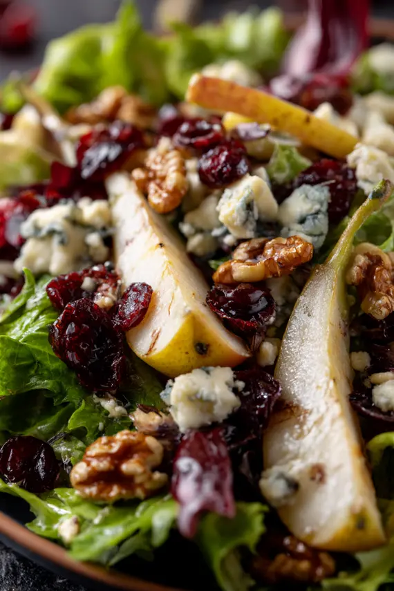 Plated Pear Gorgonzola Salad with walnuts and cranberries on a white plate