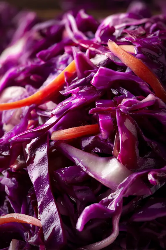 Prepared red cabbage salad in a white serving bowl showing vibrant purple and orange colors